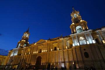 Fototapeta premium The illuminated Arequipa Cathedral stands majestically against the twilight sky, showcasing baroque architecture in Peru's heart