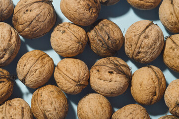 minimal close up whole walnuts on blue background, copy space, frame, top down view