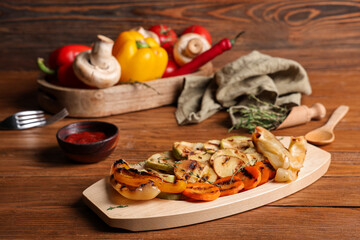 Tray with grilled vegetables on wooden table