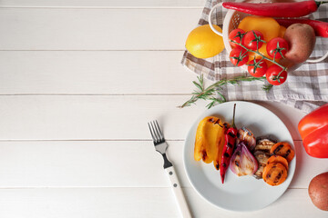 Plate with tasty grilled vegetables, rosemary and lemon on white wooden background
