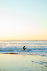Fototapeta premium surfer watching the sea preparing the next wave at sunset