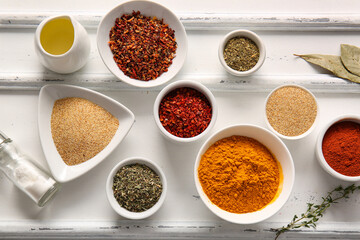 Composition with different bowls of fresh spices on light background