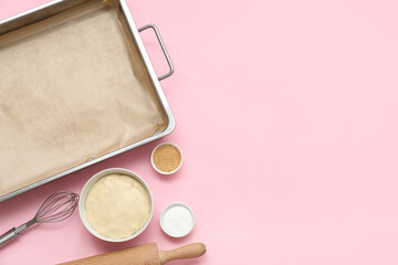 Composition with baking tray, kitchen utensils, raw dough and spices on pink background