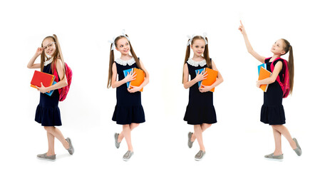 Obraz premium Happy cute child girl in school uniform holding books.