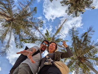 Couple sharing joy, romance, and friendship while embracing affection on a tropical journey under palm trees in paradise