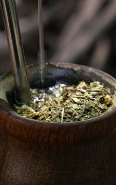 detalle de un mate argentino de madera con agua caliente cayendo