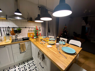 Table served for Christmas dinner in living room. Christmas tree background