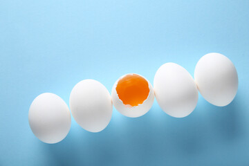 Raw chicken eggs on blue background
