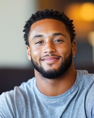 Obraz premium A young man with a friendly smile enjoys the moment while seated in a relaxed indoor atmosphere