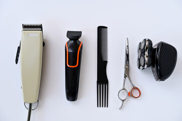 barber's tools, hair clipper, trimmer, shaver, comb and scissors on a white background