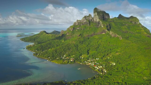 Breathtaking aerial view of Bora Bora island lagoon showing its lush green vegetation, turquoise coral reef, and majestic mount Otemanu. Aerial drone shot. French Polynesia travel tropical paradise