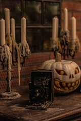 Still life with an old retro film camera and a Halloween pumpkin