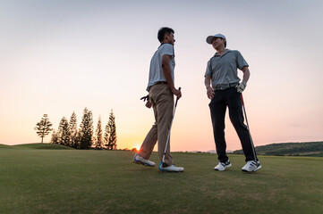 fairway, golf, golf course, golfer, tee, together, course, trainer, competition, player. Two men are standing on a golf course, one of them is wearing a hat. They are talking to each other.