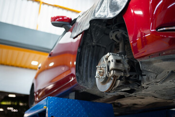 maintenance, garage, vehicle, engine, industrial, automobile, technician, inspection, system, mechanical. A red car with a black cloth on the back. The cloth is covering the rear end of the car.