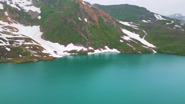 Dudipatsar Lake, a pristine blue alpine lake nestled among the snow-capped mountains of Pakistan's Kaghan Valley.