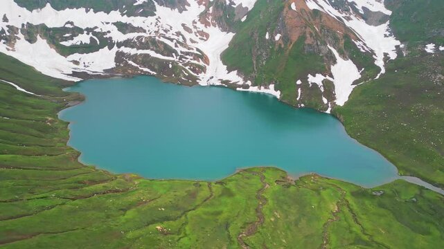 Dudipatsar Lake, a pristine blue alpine lake nestled among the snow-capped mountains of Pakistan's Kaghan Valley.