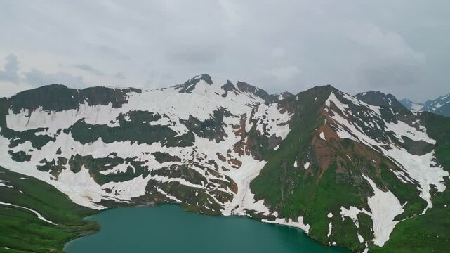 Dudipatsar Lake, a pristine blue alpine lake nestled among the snow-capped mountains of Pakistan's Kaghan Valley.