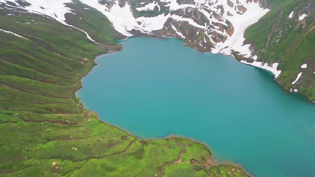 Dudipatsar Lake, a pristine blue alpine lake nestled among the snow-capped mountains of Pakistan's Kaghan Valley.