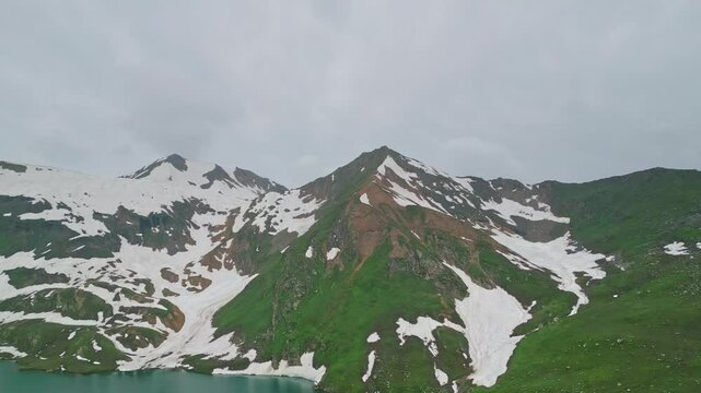 Dudipatsar Lake, a pristine blue alpine lake nestled among the snow-capped mountains of Pakistan's Kaghan Valley.