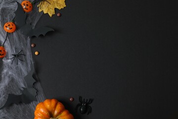 Different Halloween decorations including pumpkins, bats, spiders, confetti on black background