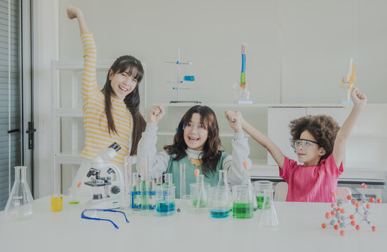 Child kid girl asian young student education tree people team group learning and smile have fun happy enjoy with science lab technology with in school classroom has tubetest microscope chemicals table