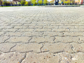 A close-up view of a concrete pavement surface, showcasing interlocking pavers arranged in a diagonal pattern