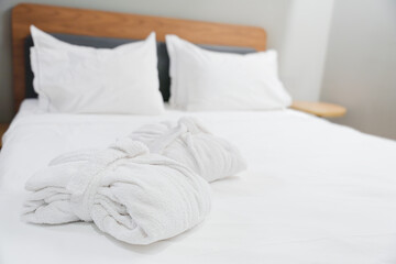 Folded Terry Robes On Bed With White Linens