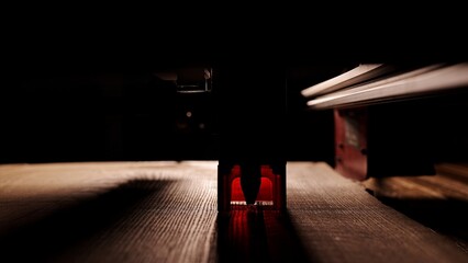 The process of laser wood cutting. A laser machine precisely carves lines on the surface, creating...