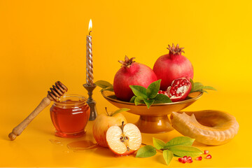 Shofar, apple, pomegranate and honey on yellow background. Rosh Hashanah (jewish holiday) concept.