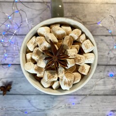 Cozy winter photo with coffee and marshmallow and garland christmas new year holiday home 