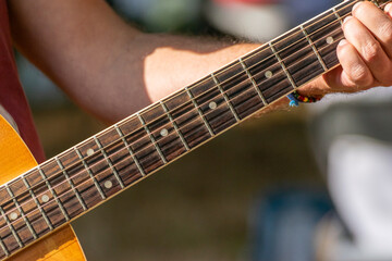 fingers of a man's hand playing a note on a Spanish guitar, music concept