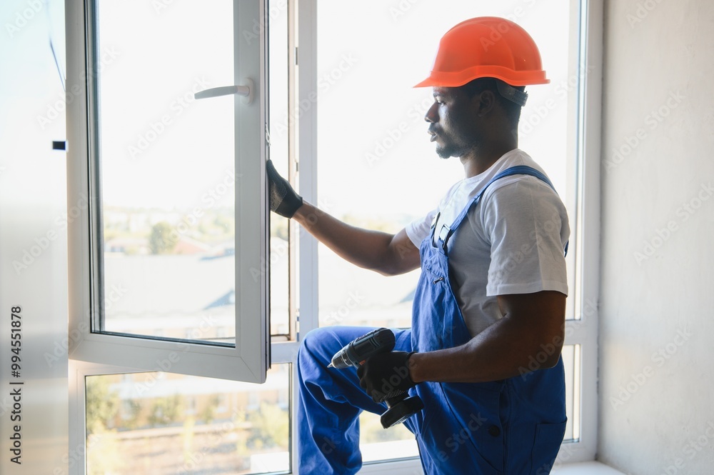 Wall mural worker installing plastic window indoors