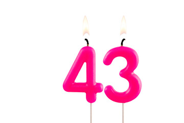 Pink number 43 birthday candle lit on white background
