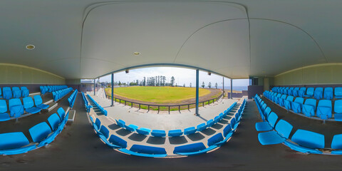An immersive 360-degree equirectangular panoramic photograph of the Kiama Showground sports field from the seating pavilion in Kiama in New South Wales, Australia.