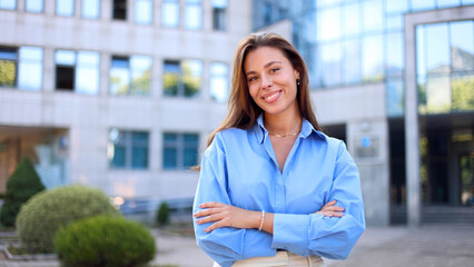 Joyful young professional stands on the street with a warm smile