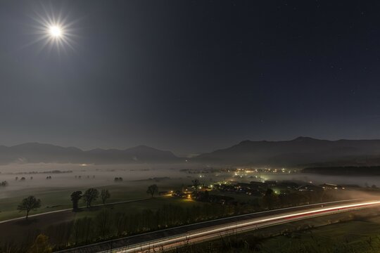 Night shot of a motorway, villages, full moon, fog, mountains, A 95, near Gro&szlig;weil, behind Jochberg, Herzogstand, Heimgarten, Bavaria, Germany, Europe