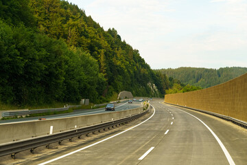 Winding highway through lush green mountains captured during a tranquil evening drive in the countryside