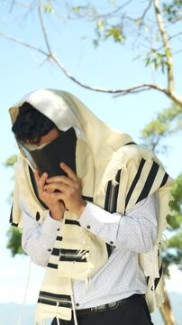 Jewish Man Covering His Face with Prayer Book During Shema Israel Recitation