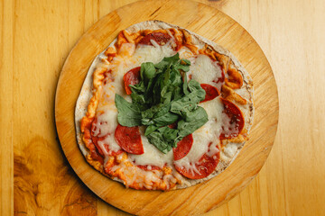 A pizza topped with pepperoni and cheese on a wooden board