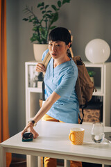 Asian woman healthcare worker leaving house rushed grabbing essentials