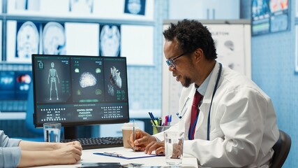 Physician explaining diagnostic report to woman patient in cabinet, discussing about health insurance and medical services. African american doctor gives advice and feedback to client. Camera A.