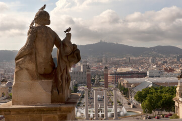 A captivating view of Barcelona&rsquo;s skyline from behind a stone statue at the National Art Museum of Catalonia, offering a stunning perspective of the city&rsquo;s architecture, 