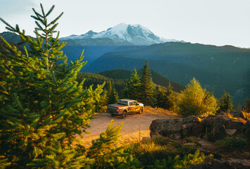 A shot of a pick up truck in front of Mount Rainier during the sunset. A perfect spot for camping...