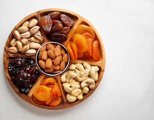 Healthy food background. Assortment of nuts and dried fruits on white background. Top view with copy space	