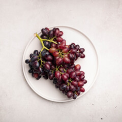 Beautiful cluster of grapes on a large white plate, top view