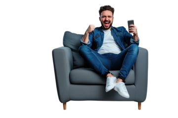 Excited Man Celebrating Victory on Smartphone While Sitting on Comfortable Armchair - Isolated Transparent Background PNG