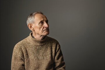 Sad senior man isolated on gray background. Studio portrait. Dementia and Alzheimer's disease concept. Memory loss awareness. Banner with copy space