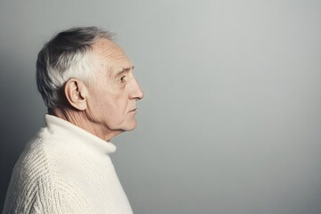 Fototapeta premium Sad senior man isolated on gray background. Studio portrait. Dementia and Alzheimer's disease concept. Memory loss awareness. Banner with copy space