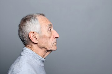 Sad senior man isolated on gray background. Studio portrait. Dementia and Alzheimer's disease concept. Memory loss awareness. Banner with copy space