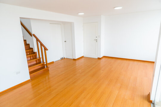 sala de departamento con escalera y acabados de madera